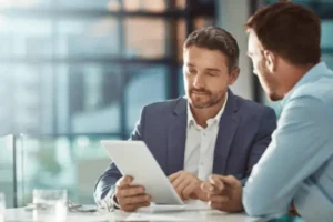 Asesor revisando documentos con cliente para crear tu empresa rápidamente y sin complicaciones.